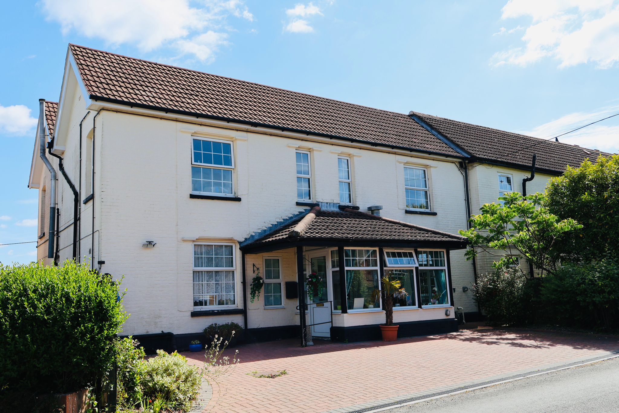 The front entrance and cream exterior of Woodfalls Care Home. For the Media & Testimonials page with Woodfalls Care Home reviews